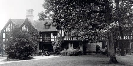 An old black and white photo of the Humanities Building, with a Ford Model T parked in front