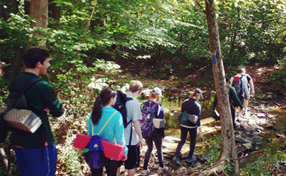 A group of people hiking down a trail in a wooded area of Gunpowder Falls State Park